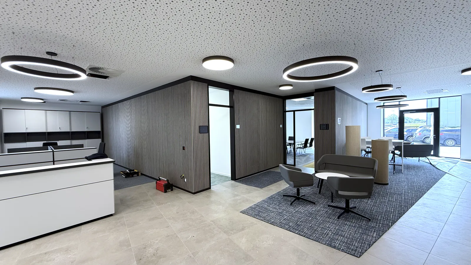 Modern ausgebautes Büro mit Akustikdecke, Glastrennwänden und Holzlamellen – hochwertiger Innenausbau von Trockenbau Plus